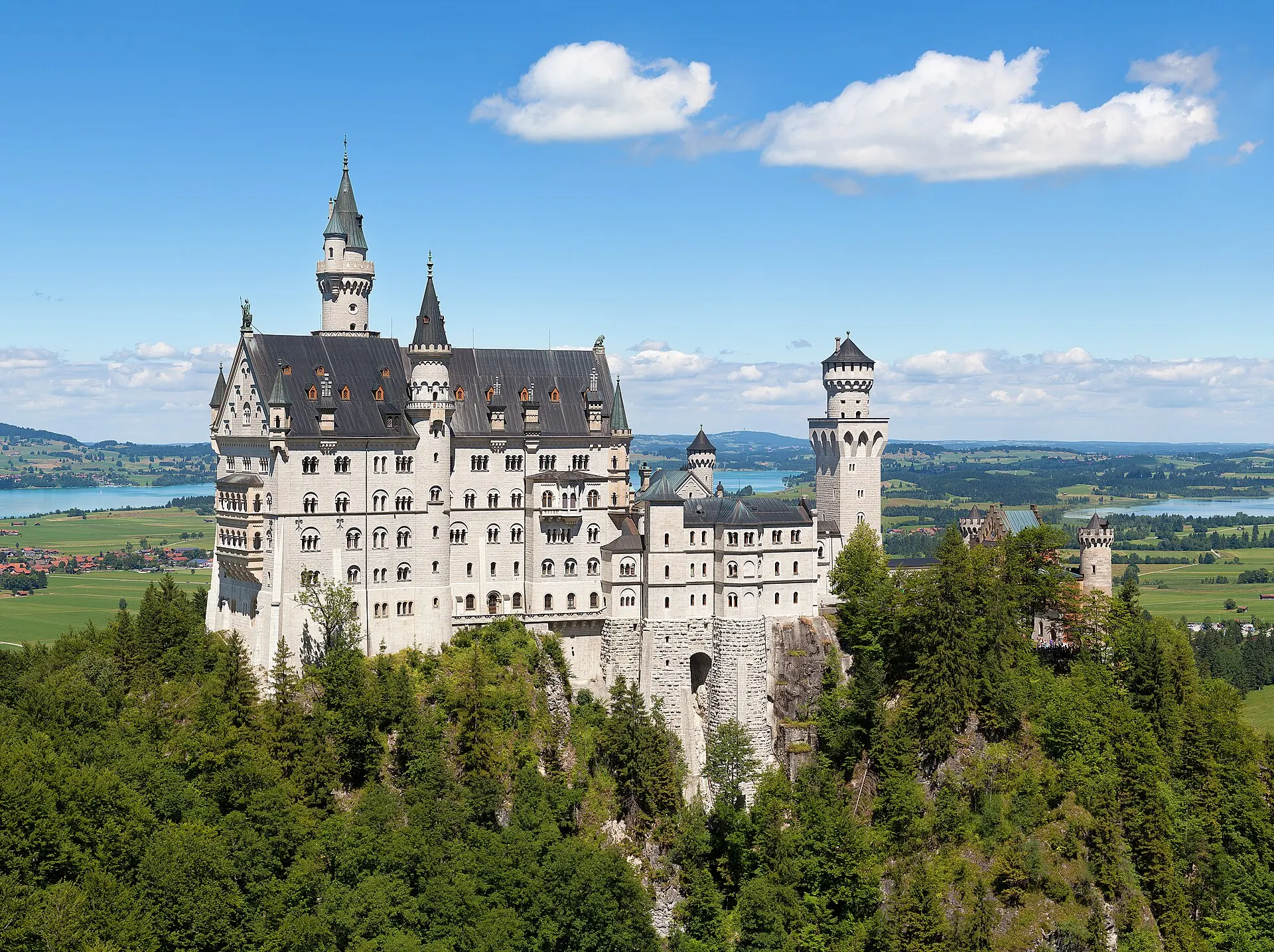 Real photo: Neuschwanstein Castle above the Bavarian countryside.